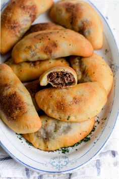 some very tasty looking pastries on a white and blue plate with parsley