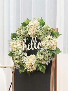 a wreath with the word hello written on it is sitting in front of a chair