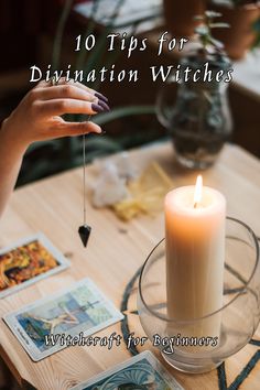 a person holding a candle on top of a table with tarot cards around it