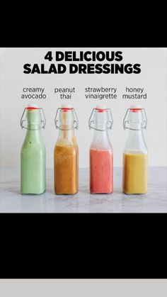 four different types of salad dressings in small glass bottles on a marble countertop