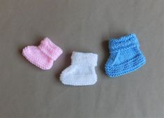 three knitted baby booties laying on top of a table