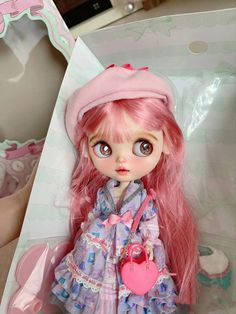 a doll with pink hair in a box