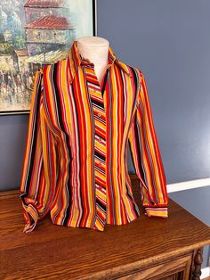 Ladies size 11-12 polyester shirt - I feel it is a Small/Medium or 6/8 with today's sizing  runs small - see measurements for sizing  bright colors red orange and yellow  vintage shirt  70s small plastic buttons button up shirt striped design Collared Orange Shirt With Buttons, Orange Collared Shirt With Buttons, Retro Multicolor Button-up Shirt, Retro Orange Collared Shirt, Red Retro Print Shirt For Spring, Vintage Multicolor Tops With Button Closure, Orange Button-up Shirt With Button Closure, Retro Long Sleeve Orange Blouse, Retro Orange Long Sleeve Shirt