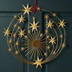 a christmas ornament hanging on a door with stars in the center and red ribbon