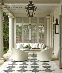 a porch with white furniture and black and white checkered flooring