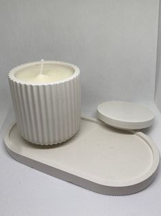 a white candle sitting on top of a tray