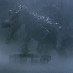 godzilla walking in the rain with it's head on top of a box and its mouth open