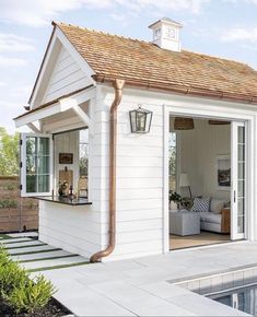 a small white house sitting next to a swimming pool