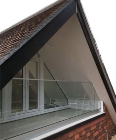 an open window on the side of a building with brick walls and shingled roof