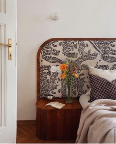 a vase with flowers sitting on top of a bed