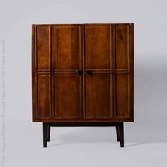 an old wooden cabinet with four doors and two drawers on one side, against a white background