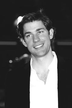 a black and white photo of a man smiling