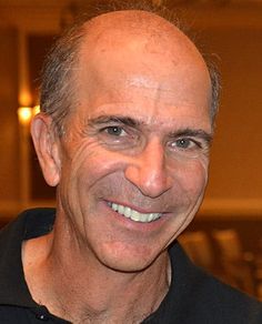 a close up of a person wearing a black shirt and smiling at the camera,