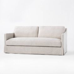 a white couch sitting on top of a white floor