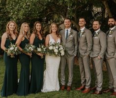 a group of people standing next to each other in front of some trees and grass