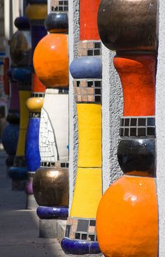 many different colored vases lined up on the side of a building