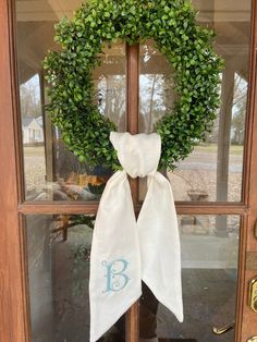 a wreath with the letter b is hanging on a door