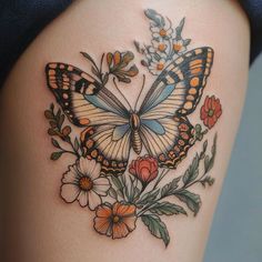 a woman's thigh with a butterfly and flowers on it