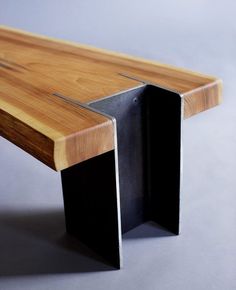 a close up of a wooden bench with black metal legs and wood grain on the edge