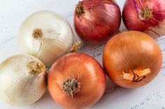 four onions are sitting next to each other on a white surface with one onion in the middle