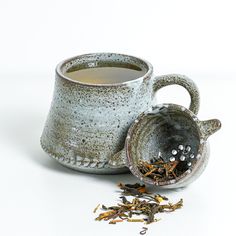 This ceramic mug set features a glossy, slightly-textured exterior and is an ideal present for yourself or someone you care about. It includes a convenient strainer for preparing loose-leaf tea blends for your morning or afternoon cup. Ceramic Tea Diffuser, Ceramic Tea Strainer Infuser, Tea Infuser Ceramic, Pottery Coffee Cup, Mug Texture, Ceramic Tea Strainer, Cafe Mugs, Ceramic Carafe, Leaf Mug