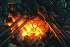 a close up of coal and tongs near a fire