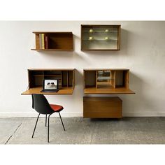 a chair and desk in front of a wall with bookshelves on the shelves