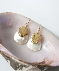 "Vacation vibes are high with our Seycha Resort Earrings. Layers of Mother of Pearl and Gold Monstera leaves give this style a rich yet breezy appearance. This lightweight design is full or movement and shimmer. Our Seycha Collection also includes: Huggie Hoops >> https://www.etsy.com/listing/1155094970 Larger Hoops >> https://www.etsy.com/listing/1169428021 Pendant necklace >> https://www.etsy.com/listing/1169592517 MATERIALS Mother of Pearl, 14k Gold Filled wires, Heavy Gold Plate Charms (anti Elegant Dangle Earrings For Vacation, Elegant Earrings With Ear Wire For Vacation, Elegant Gold Earrings For Vacation, Mother Of Pearl Drop Necklace, Gold Monstera Leaf, Monstera Leaf Earrings, Pearl Earrings Gold, Tropical Jewelry, Pearl Drop Necklace