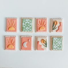 some small cookies with designs on them sitting in front of a white tablecloth and wall