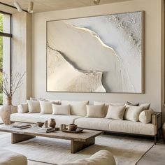 a living room filled with furniture and a large painting hanging on the wall above it