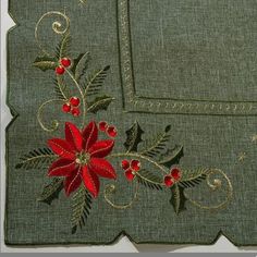 a close up of a piece of cloth with flowers and leaves embroidered on it's side