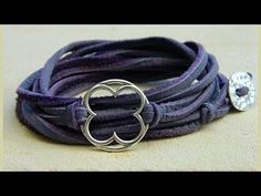 there is a purple leather bracelet with a silver ring on it