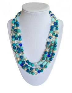 This long classic turquoise blued necklace is perfect for your beach vacation or your summer stay-cation. This long — very long — necklace (with clasp) is great worn alone or wrapped for a shorter, three-strand sophisticated look. Each hand-made necklace from the Classic Collection incorporates Swarovski crystals, freshwater pearls, color-coordinated turquoise beads and other blue stones and Silver accents in its design. You'll feel soft and feminine when you wear this necklace, whether that is Elegant Blue Turquoise Necklace For Beach, Blue Double Strand Beaded Necklace For Beach, Elegant Turquoise Necklace For Beach, Elegant Turquoise Necklace With Round Beads For Beach, Turquoise Double Strand Beaded Necklace For Beach, Double Strand Turquoise Beaded Necklace For Beach, Elegant Double Strand Blue Turquoise Necklace, Elegant Turquoise Long Necklace With Round Beads, Elegant Double Strand Beaded Necklace For Beach