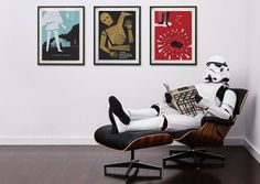 a man sitting in a chair reading a book while wearing a stormtrooper costume