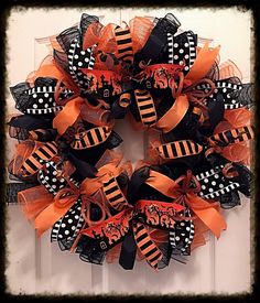 a halloween wreath with black and orange decorations