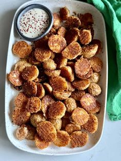 a white plate topped with fried food next to a green towel