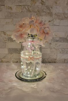 a glass jar filled with flowers on top of a table