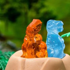 two gummy bears sitting on top of each other next to a toothbrush holder