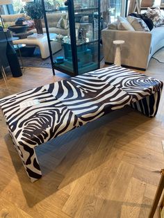 a zebra print bench sitting on top of a hard wood floor