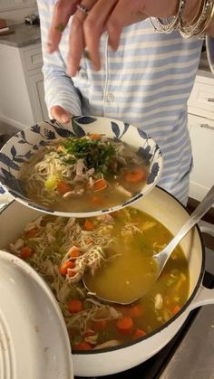 two bowls of soup are being held over the stove top by someone's hands