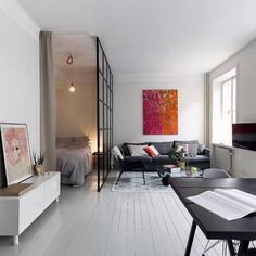 a living room filled with furniture and a flat screen tv sitting on top of a hard wood floor