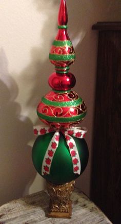 a green and red christmas tree sitting on top of a table