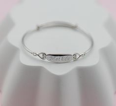 Personalized sterling silver dainty bangle featuring a silver engraved oval in the center accented with hearts on either side. This keepsake piece is rhodium plated to prevent tarnish and is an adorable gift for baptism, birthdays, first communion, or a special gift from grandma.   💜 Comes with FREE engraving (up to 9 characters) 💜 This bracelet is adjustable, just slide for the perfect fit! With the adjustable feature this fits 1-10 years or a small adult. (43mm in diameter when fully closed Engraved Bangle, Baby Bangles, Beautiful Gift Boxes, Custom Engraving, Cute Gifts, Bangle Bracelets, Special Gifts, Jewelry Bracelets, Bangles