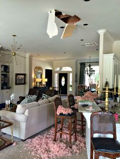 a living room filled with furniture and lots of pink flowers on the floor next to a doorway