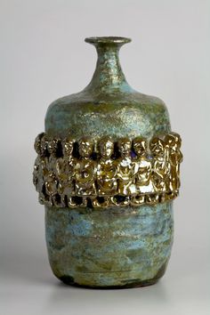 a green vase sitting on top of a white table