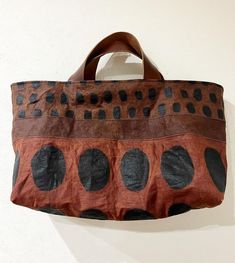 a handbag hanging on the wall with polka dots and circles painted on it's side