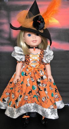 a doll wearing an orange and black dress with a hat on it's head