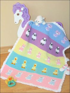 a crocheted blanket and stuffed animal are on the floor next to a toy horse