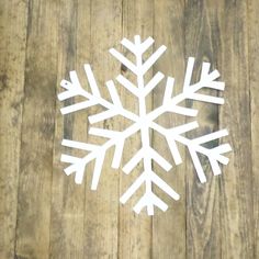 a white snowflake sitting on top of a wooden floor