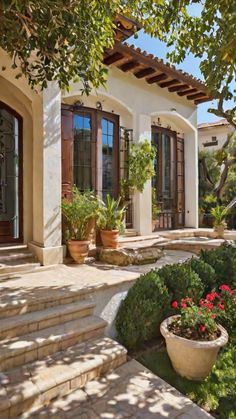 a house with steps leading up to it and potted plants in the front yard